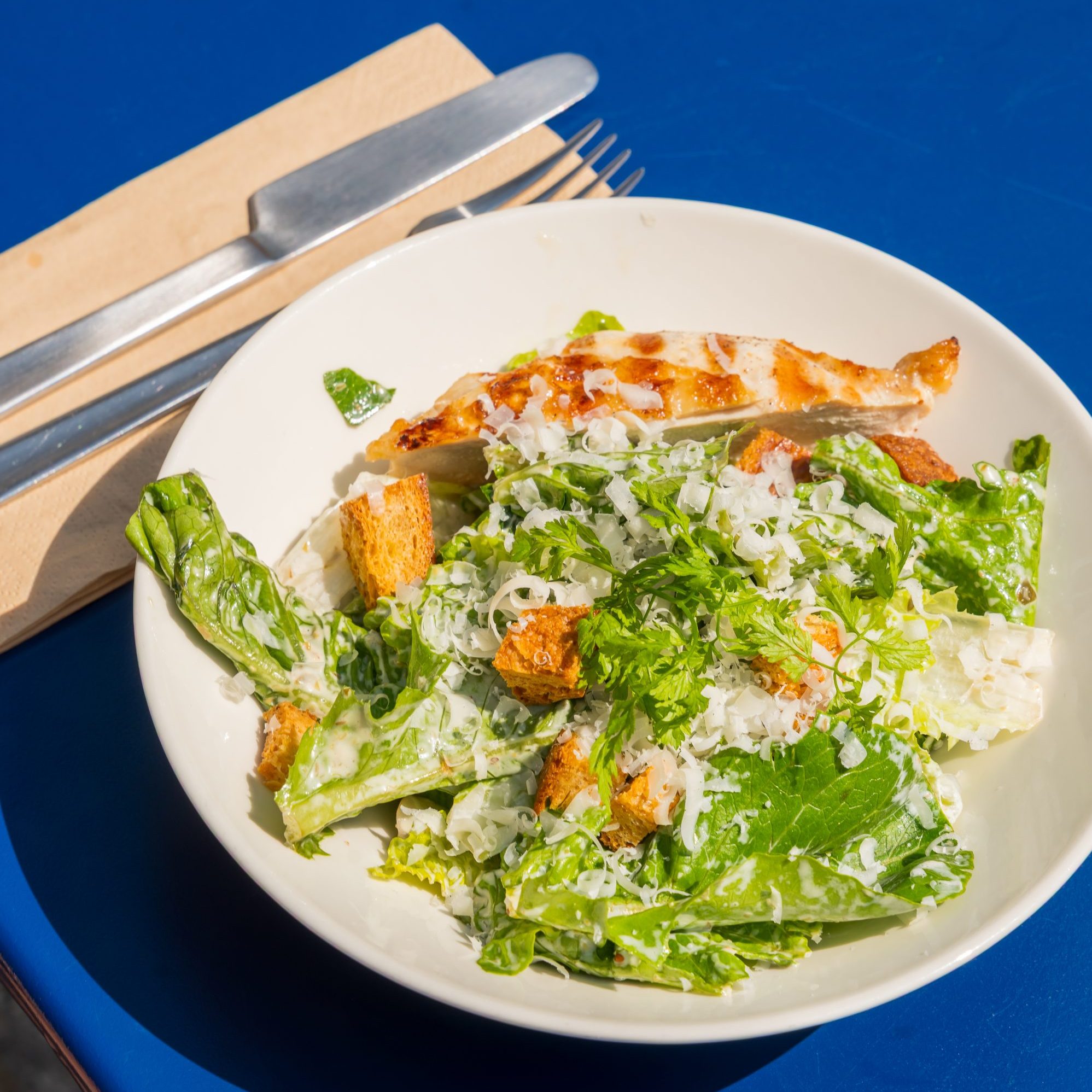 Cæsarsalat i FORMATs udendørs caféområde med udsigt til museumsbygningen.
