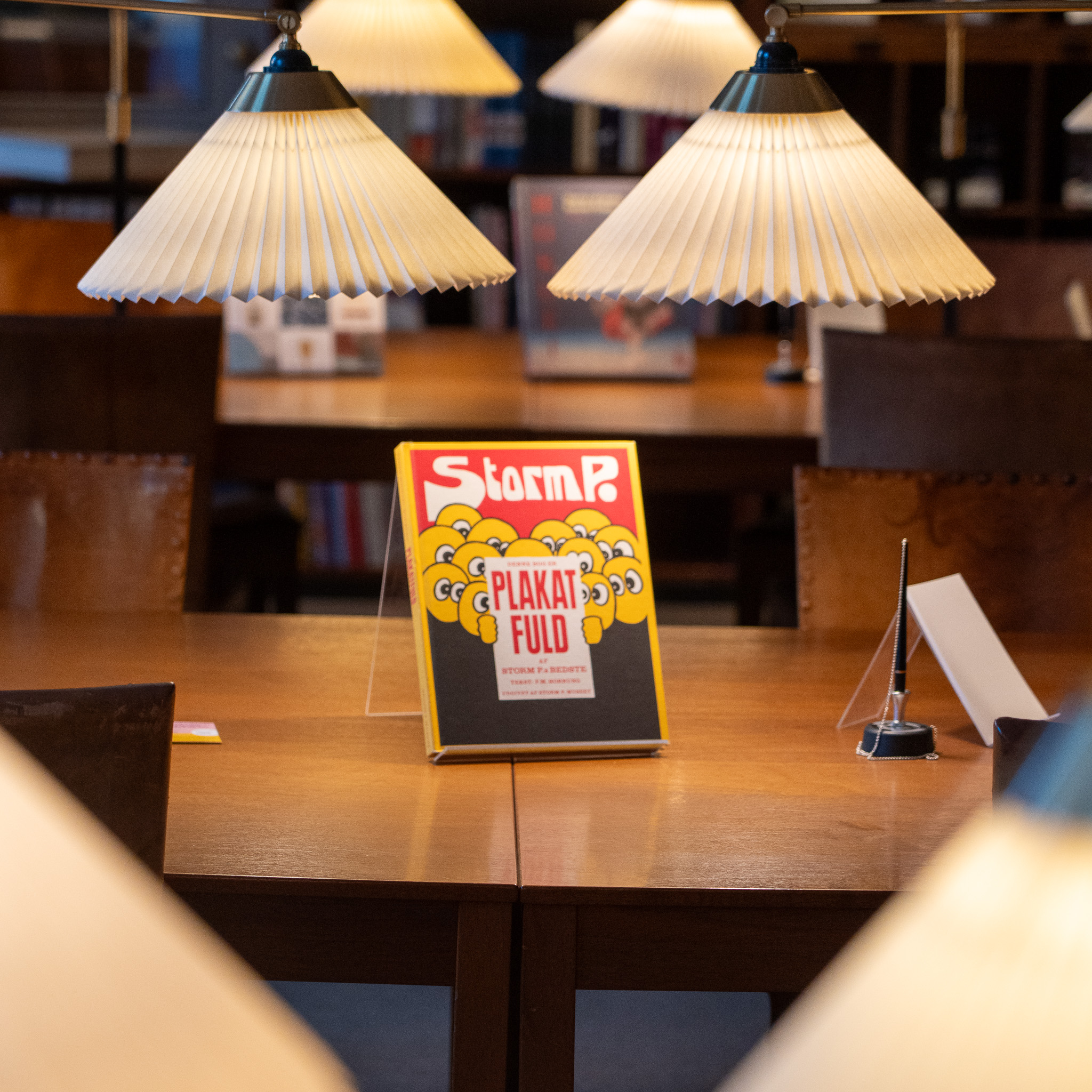 'Plakat Fuld' af Storm P. og Kaare Klint lamper på biblioteket.